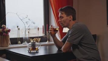 A white man at home drinking tea and looking out the window video