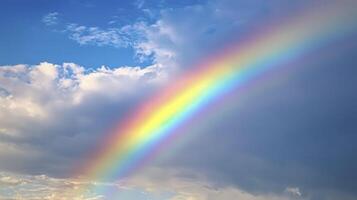 A vibrant rainbow arcing across a partly cloudy sky after a light rain shower in the early evening photo