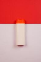 Plastic shampoo bottle with flip-top lid isolated on red and white background. MockUp template for your design. Empty and clean packaging for cosmetic product. File contains clipping path. photo