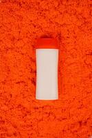 Plastic shampoo bottle with flip-top lid isolated on orange sand background. MockUp template for your design. Empty and clean packaging for cosmetic product. File contains clipping path. photo