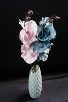 Pink and grey spring flowers in a vase on black background. High resolution photo. Selective focus. photo