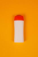 Plastic shampoo bottle with flip-top lid isolated on orange background. MockUp template for your design. Empty and clean packaging for cosmetic product. File contains clipping path. photo