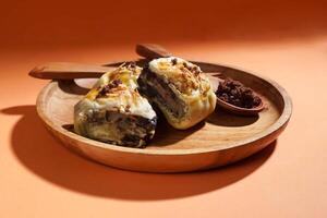 Banana Bolen is made from bananas and pastry dough, filled with chocolate and cheese. It is served on a wooden plate in a selective focus style image. photo