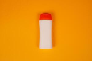 Plastic shampoo bottle with flip-top lid isolated on orange background. MockUp template for your design. Empty and clean packaging for cosmetic product. File contains clipping path. photo