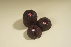 steamed brownie cake with a layer of red and white cream in the middle, isolated on yellow background photo