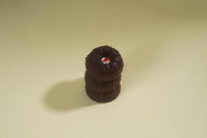 steamed brownie cake with a layer of red and white cream in the middle, isolated on yellow background photo
