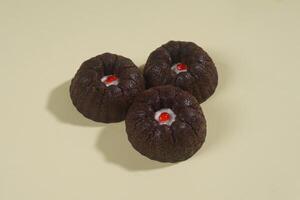 steamed brownie cake with a layer of red and white cream in the middle, isolated on yellow background photo