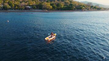 Woman travelling on kayak in ocean in Bali, Amed. Above view video