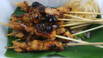 Sate or Chicken satay, rabbit, lamb satay served on banana leaf with peanut sauce photo