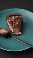 A piece of sweet cheesecake with mascarpone cheese, strawberry flavor, covered with chocolate on a dark concrete background video