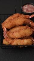 Hot crispy shrimp breaded with salt and spices with white sauce on a dark concrete background video