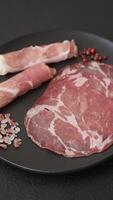 Antipasto jamon, prosciutto, sausage, sliced with tomatoes, salt and spices on a dark concrete background video