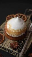 Sweet lemon tart with cream filling and zest on a dark concrete background video