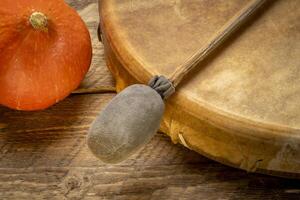 handmade, native American style, shaman frame drum covered by goat skin with a beater or a rustic wood with winter squash photo