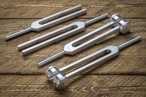 Set of weighted and unweighted metal tuning forks used for tuning musical instruments, sound therapy, chakra healing or relaxation. photo
