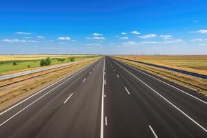 An empty highway with a blue sky and white clouds photo