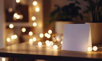A white card sits on a table in front of a string of lights photo