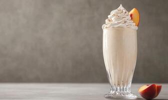 A glass of milkshake with whipped cream and a peach slice on top photo