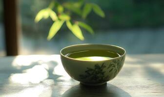 A green tea cup with a floral design sits on a table photo