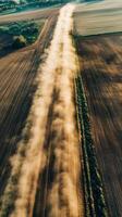Dust clouds rising from tractor paths in parched field , wallpaper art photo