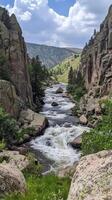 Rapids flow between rock formations toward valley , wallpaper photo