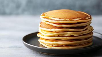 Neatly arranged stack of buttermilk pancakes on a round plate, culinary photography photo