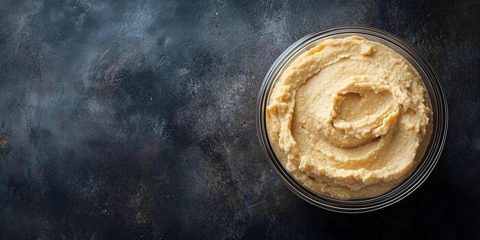 Hummus in a clear container, consistent texture, no elements, culinary photography photo