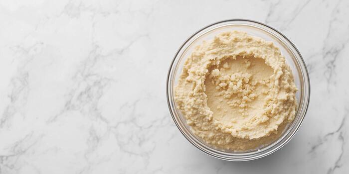 Hummus in a clear container, consistent texture, no elements, gastronomy photography photo