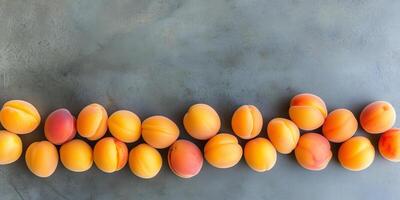 Handful of apricots in a slightly curved line on a flat surface, food setting photo