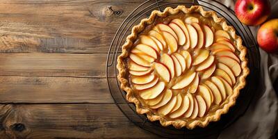 Pie with circular crust, filled with sliced apples, placed on cooling rack, food setting photo