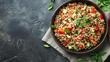 Quinoa salad in a round dish with cooked quinoa, vegetables, herbs, and nuts mixed together, meal photography photo