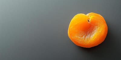 Single dried apricot centered on a smooth background, food setting photo