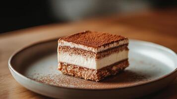 Square piece of tiramisu on a plate, highlighting the layered structure of the dessert, food photography photo