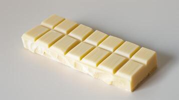 Unwrapped white chocolate bar with distinct lines separating individual segments, culinary photography photo