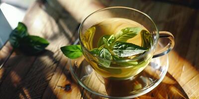 Green tea leaves floating in a clear cup of hot water on a wooden table, meal photography photo