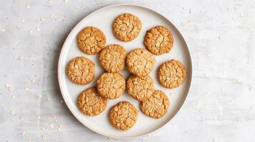 Oatmeal cookies arranged in a circular pattern on a plain white plate, food setting photo