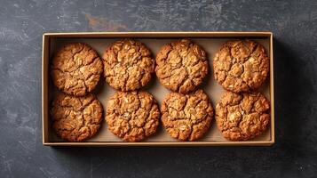 Oatmeal cookies placed in an open rectangular box with a simple design, meal photography photo