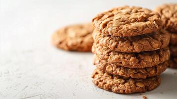 Several oatmeal cookies stacked in a neat pile on a white surface, meal photography photo