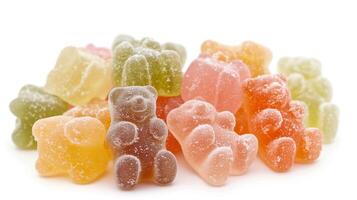Several gummy bears in assorted colors arranged in a tight cluster on a white background, food setting photo