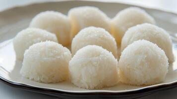 Soft round rice cakes dusted with starch on a clean white plate, meal photography photo