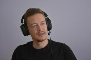 A man wearing headphones with microphone talking with colleges on a remote company conference. Professional expert speech photo