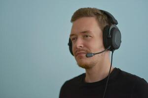 A man wearing headphones with microphone talking with colleges on a remote company conference. Professional expert speech photo