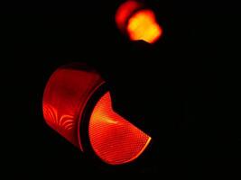 Red traffic light close up in the dark on a black background photo