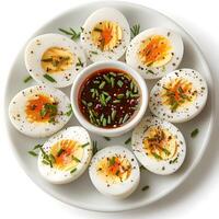A Delightful Platter of Sliced Hard-Boiled Eggs Garnished with Fresh Chives and Served with a Rich Spicy Dipping Sauce for a Flavorful Appetizer Experience photo