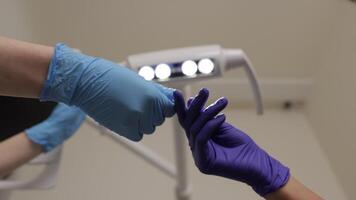 Dentist adjusts lamp before seeing patient, assistant gives instruments video