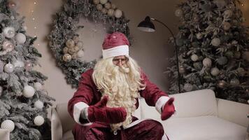 Santa claus sitting on white sofa changing poses video