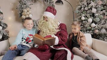 Santa claus entertaining children with a storybook while seated on a cozy sofa video