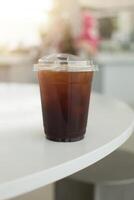 An iced Americano sits on a table, capturing the essence of a refreshing summer beverage. photo