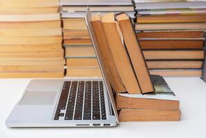 stack of books and a computer on the table photo