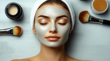 Relaxing spa treatment with a calming clay mask applied on a woman's face surrounded by cosmetic brushes and products at a beauty studio photo